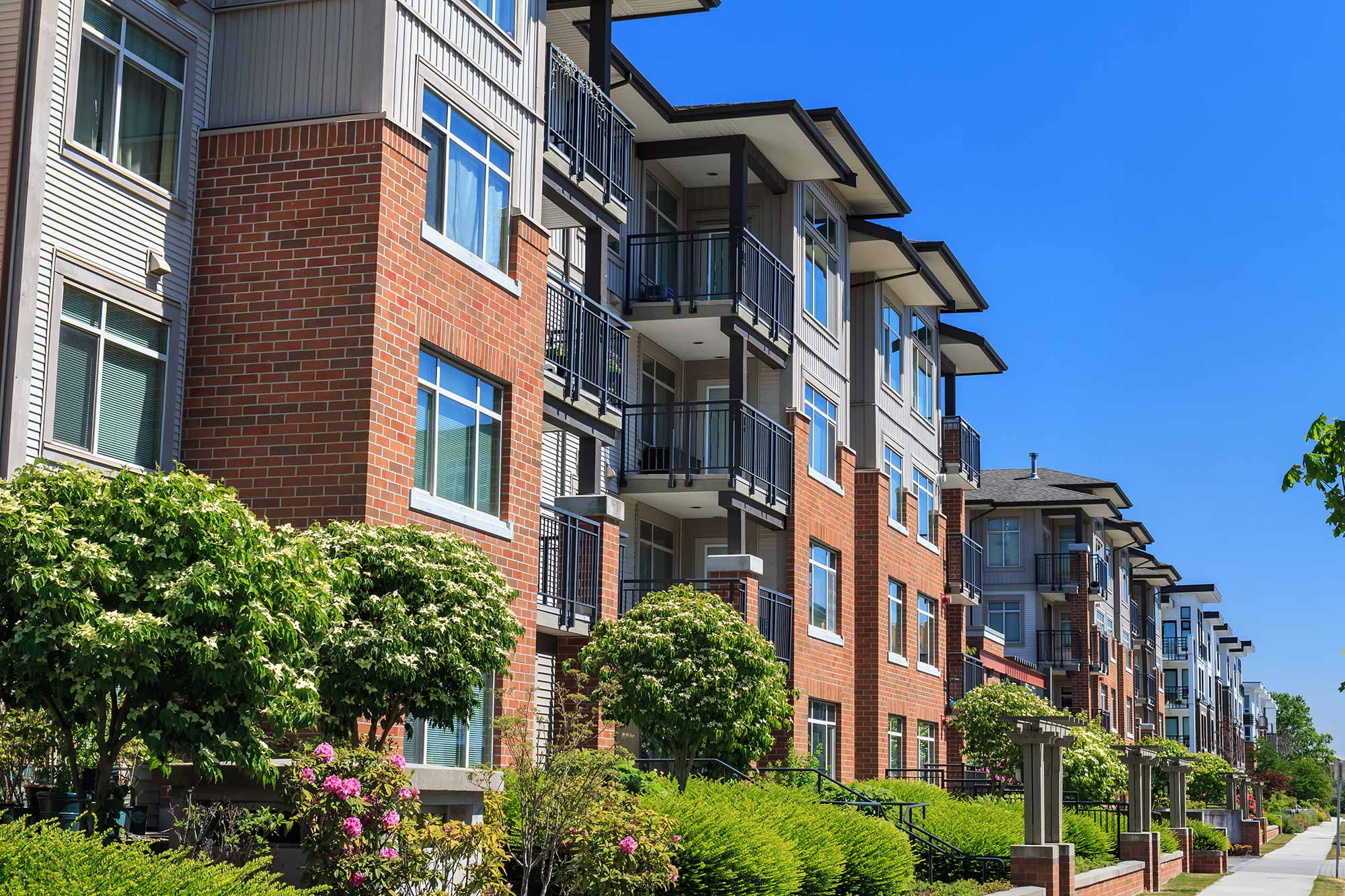Exterior shot of a block of condos on a sunny day.