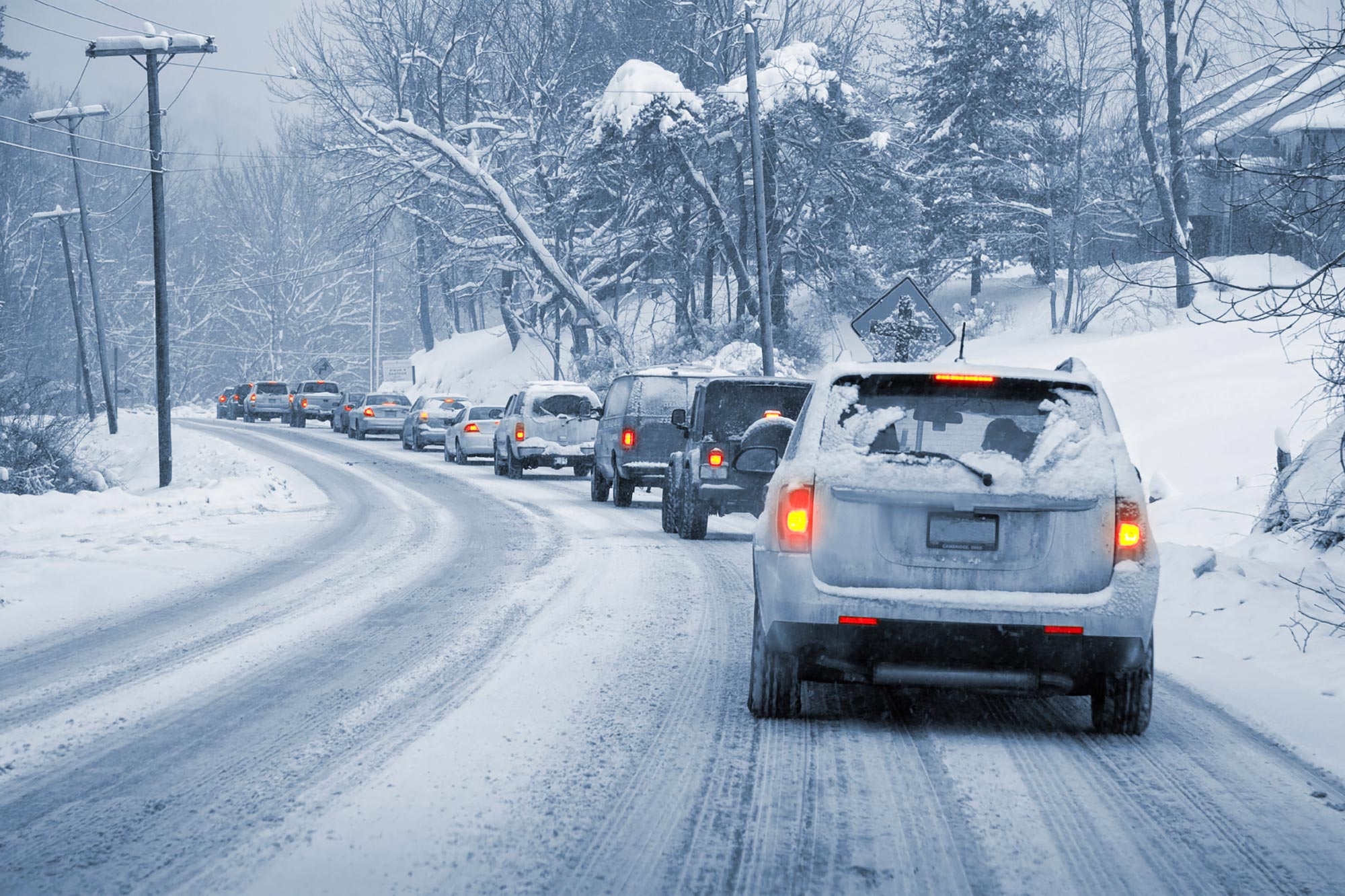 Line of vehicles in traffic on snow-covered road.