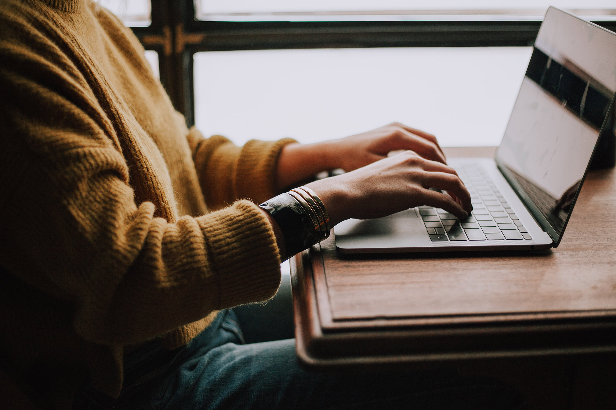Close-up of woman working on laptop.