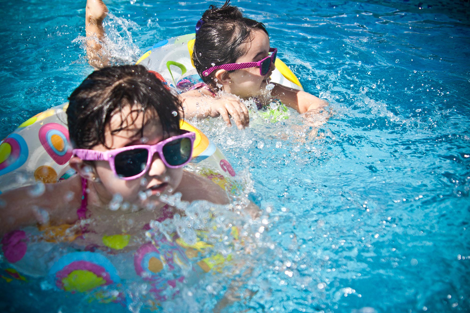 A young child swimming in a pool in an inflatable ring.