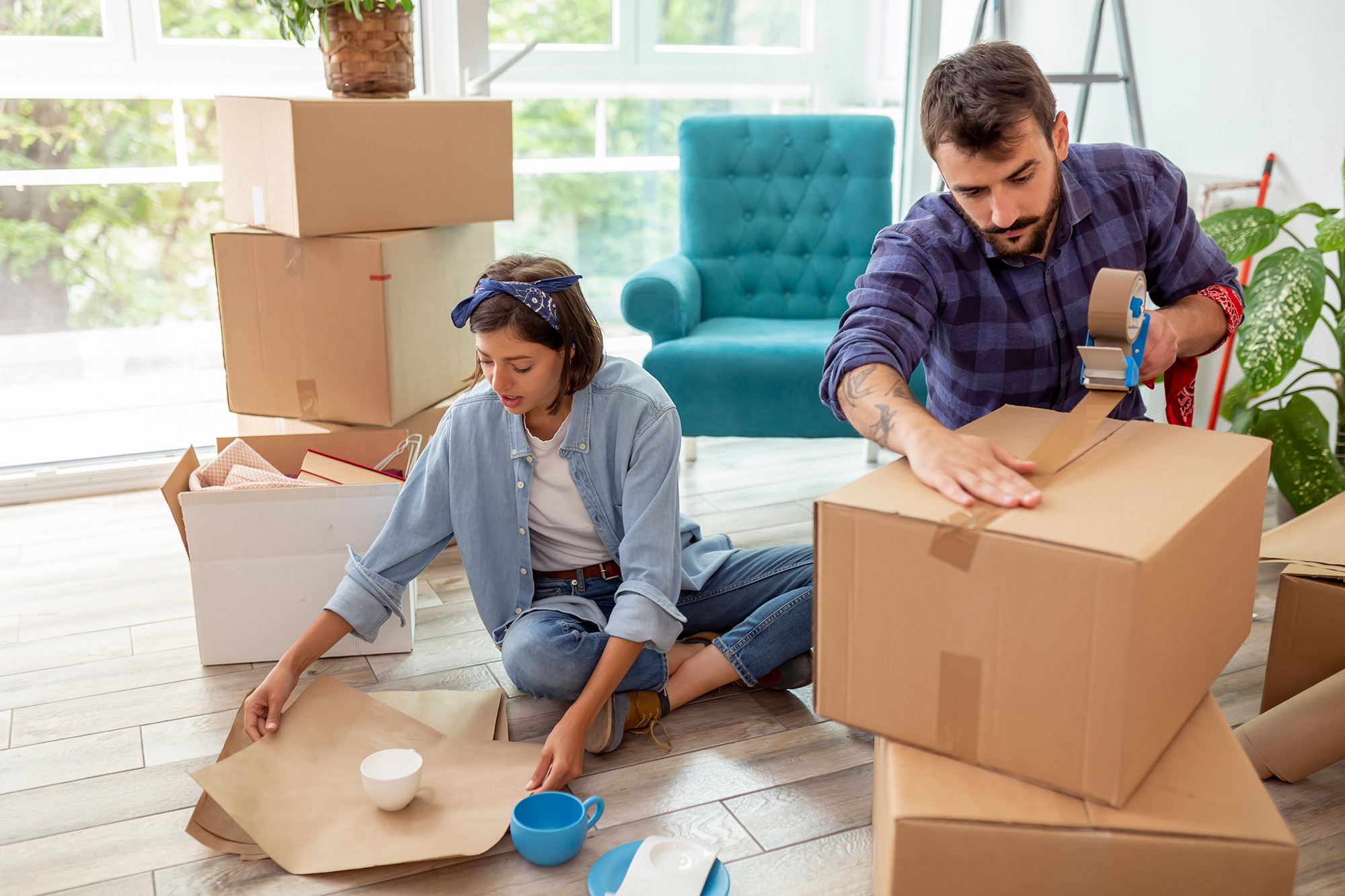 Couple packing up their belongings into cardboard boxes.