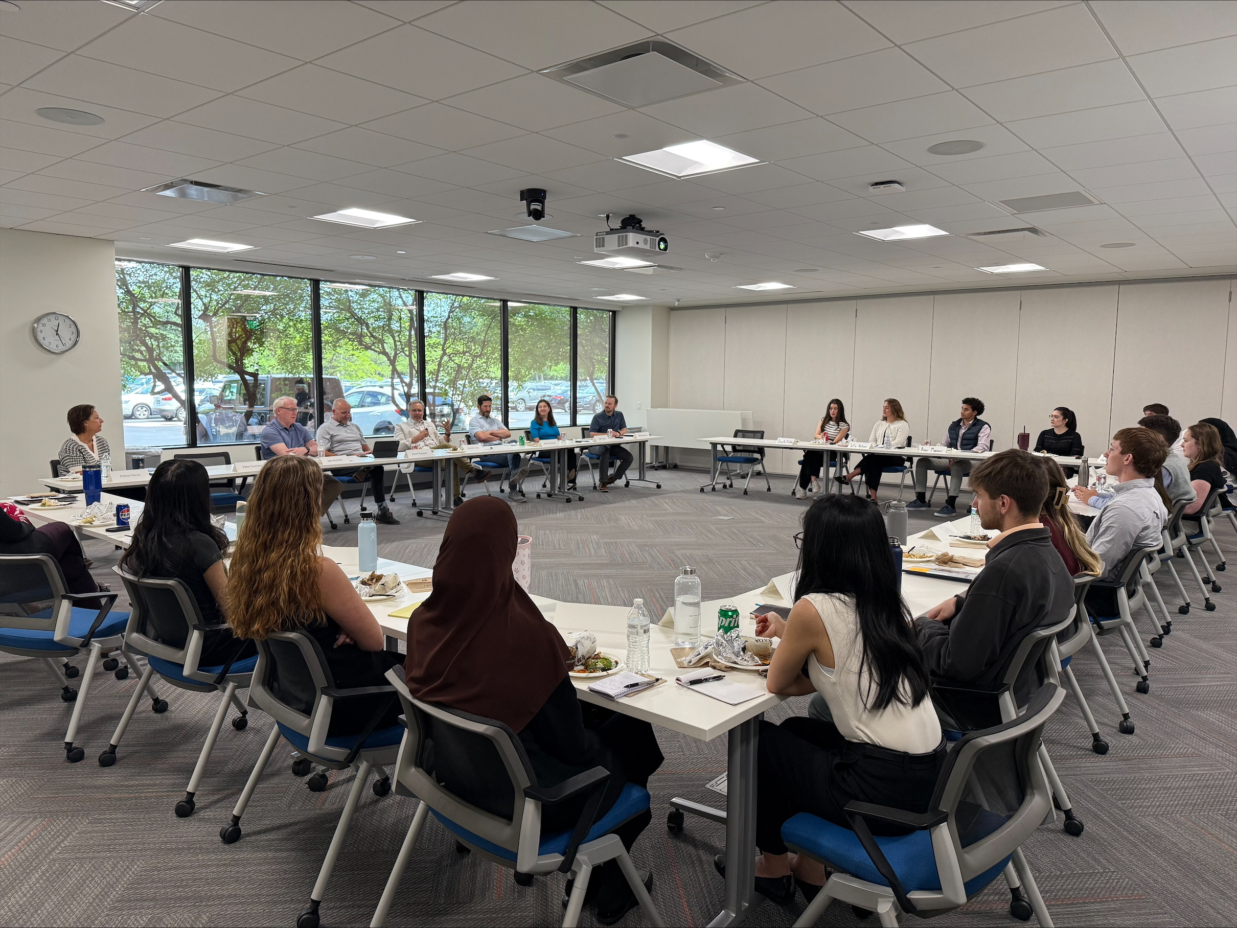 Interns and Western National senior leadership having conversations around a conference room table.
