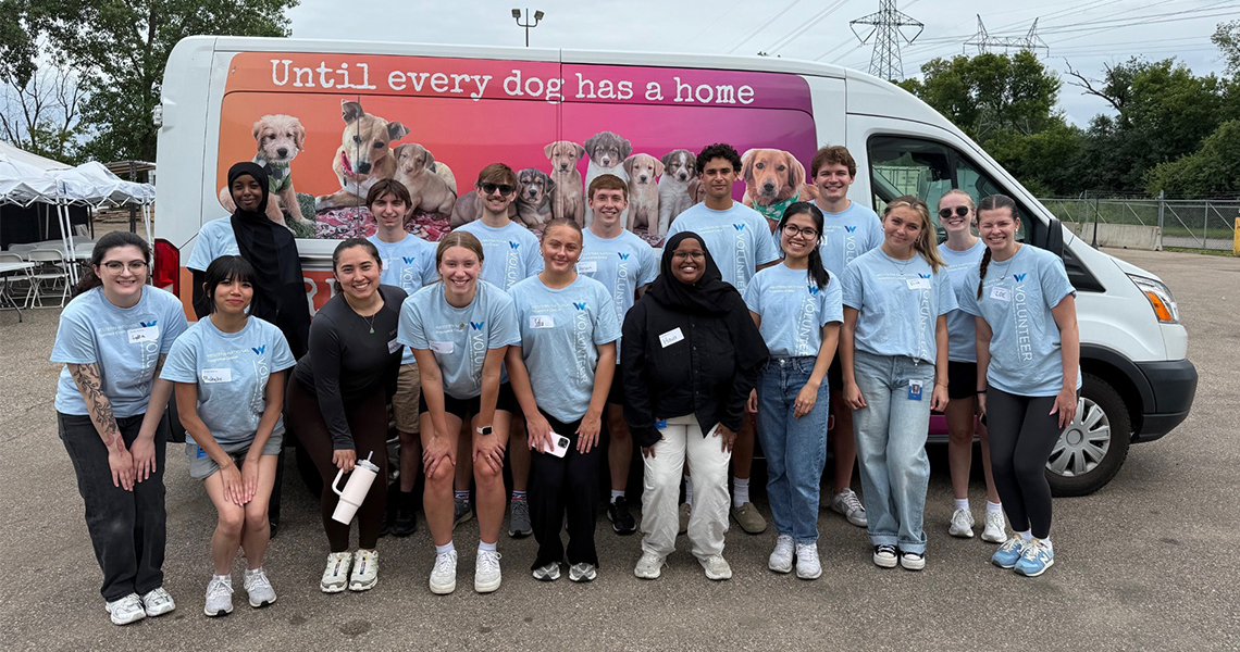 Two Western National employees with hula hoops posing together for a photos while outdoors on a sunny day.